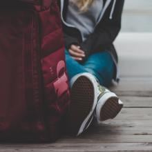 girl sitting on the ground with a backpack